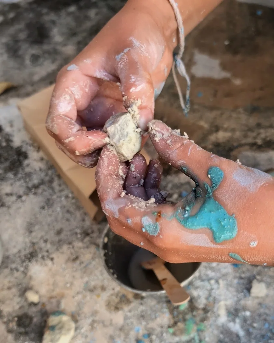 Manos de niño mezclando pigmentos de colores en un experimento